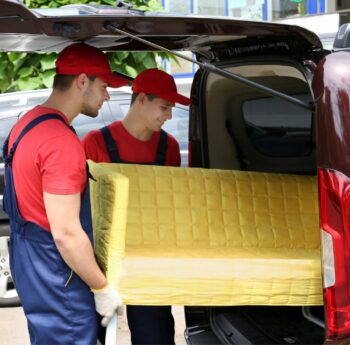 Günstig umziehen in Görlitz Günstig umziehen in Görlitz: Umzugshelfer laden ein gelbes Sofa in einen Transporter