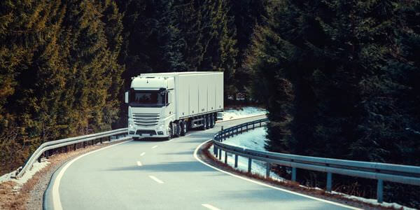 Klaviertransport Görlitz: Lkw fährt auf einer kurvigen Straße durch den Wald
