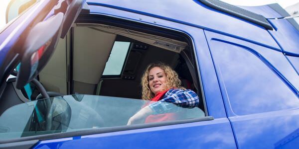 Frau am Steuer eines blauen Transporters